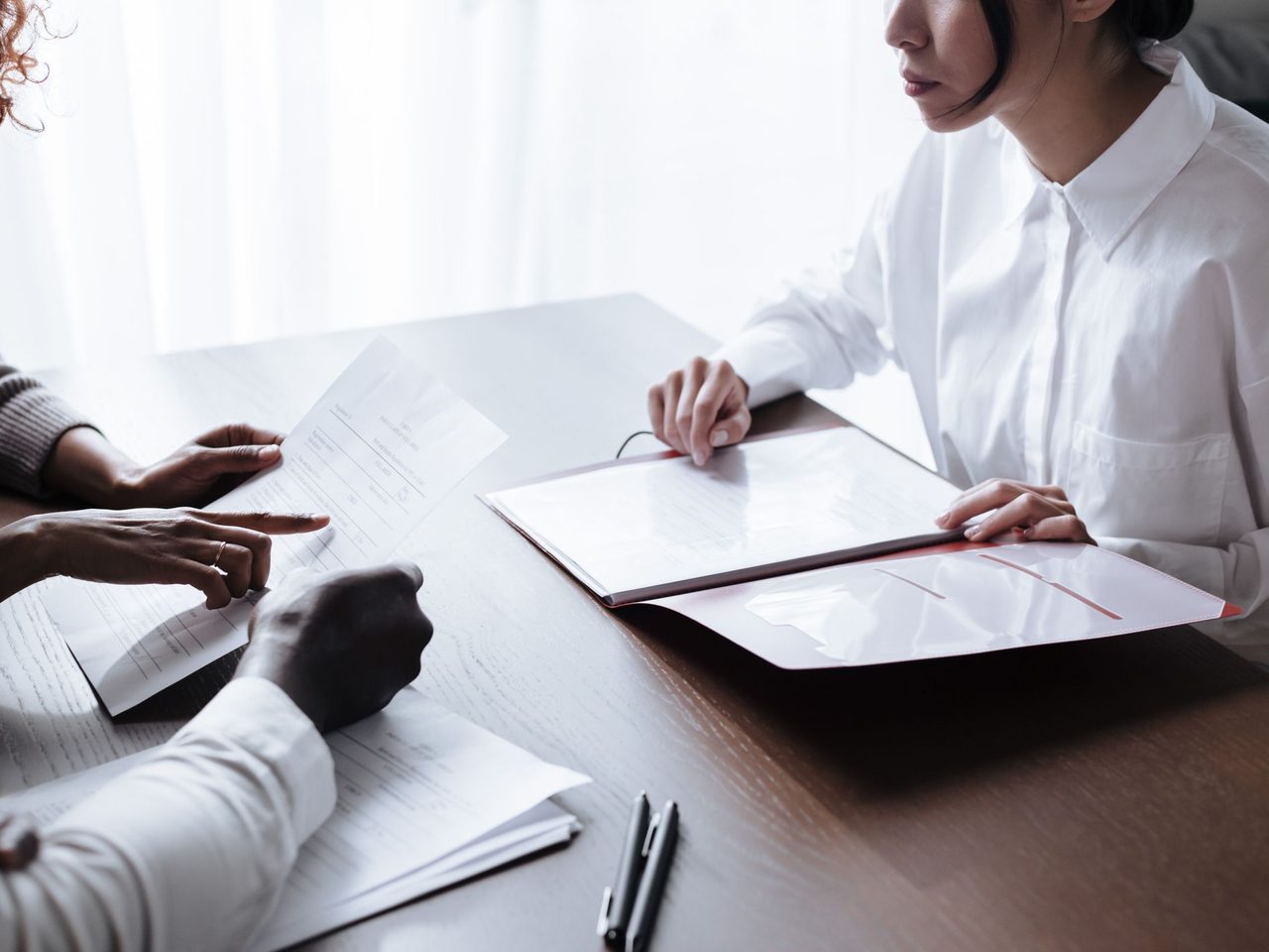 Colleagues reviewing job paperwork together at an office table
