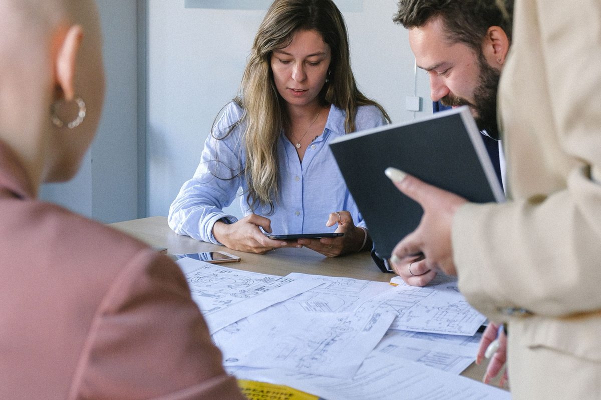 A small team reviewing technical drawings together at a table